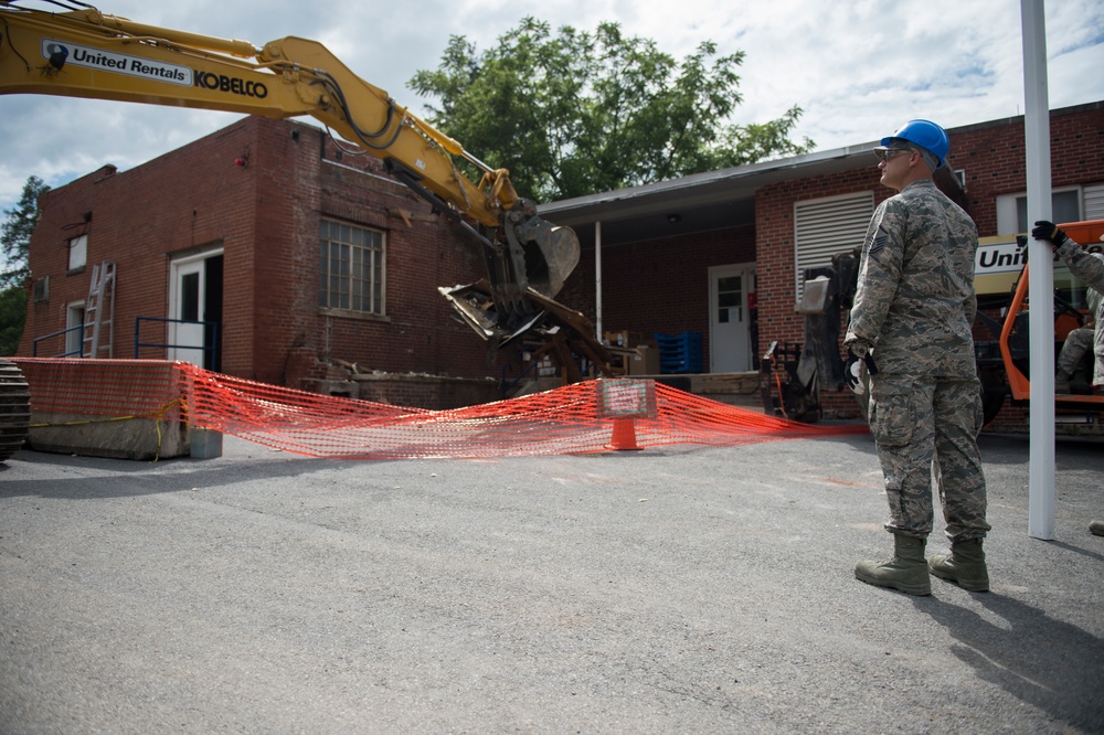 Master Sgt. Lee Keeling helps guide a heavy equipment operator at the West Virginia Schools for the Deaf and the Blind