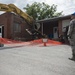 Master Sgt. Lee Keeling helps guide a heavy equipment operator at the West Virginia Schools for the Deaf and the Blind