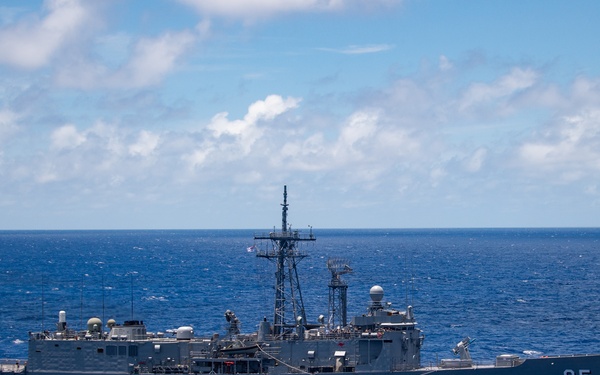A gray naval warship bearing hull number '05' is underway on open blue ocean under partly cloudy skies. The vessel appears to be a frigate-class warship, identifiable by its characteristic superstructure, mast array, and weapons systems. The ship is photographed from a slightly elevated angle, likely from another vessel or aircraft.