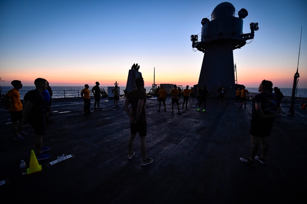 Sailors aboard the USS Mount Whitney (LCC 20) conduct a sunrise physical training session in the Mediterrranean Sea.