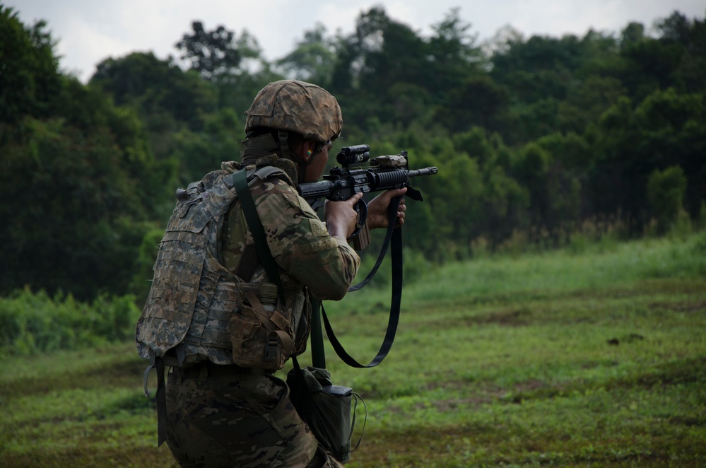 Charlie Company, 100th Infantry Regiment, storms the objective on a live fire range