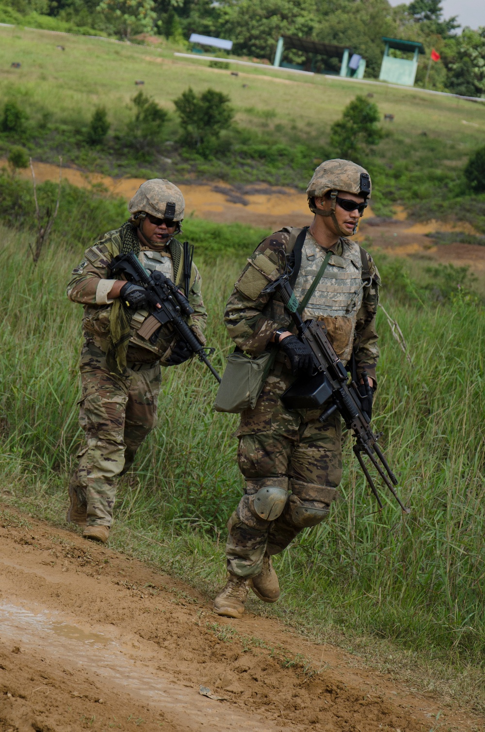 Charlie Company, 100th Infantry Regiment, storms the objective on a live fire range