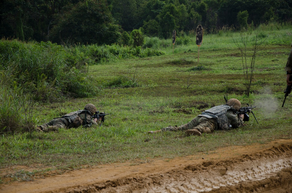 Charlie Company, 100th Infantry Regiment, storms the objective on a live fire range