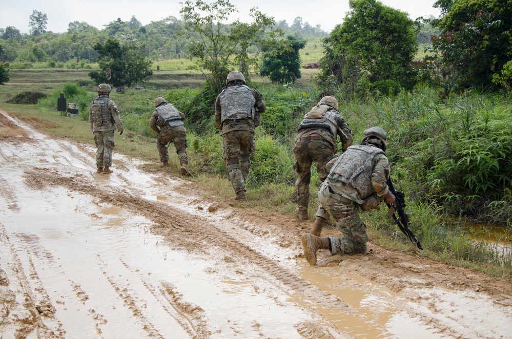 Charlie Company, 100th Infantry Regiment, storms the objective on a live fire range