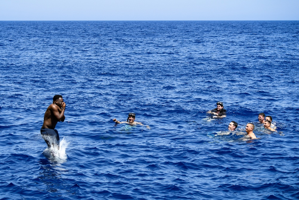 Sailors and Military Sealift Command civil service mariners participate in a swim call aboard the USS Mount Whitney (LCC 20) in in the Mediterrranean Sea.