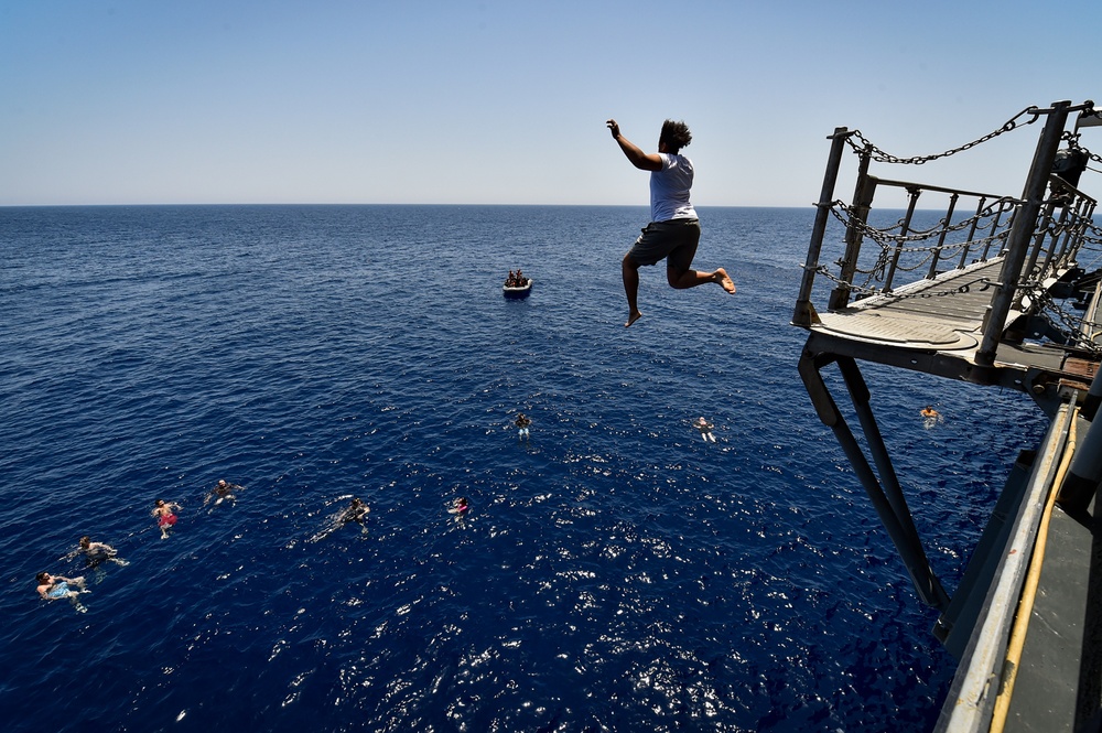 Sailors and Military Sealift Command civil service mariners participate in a swim call aboard the USS Mount Whitney (LCC 20) in in the Mediterrranean Sea.