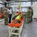 Col. Michelle M.T. Letcher, commander, Joint Munitions Command, examines pneumatic rivet removal, used to demate a Multiple Launch Rocket System warhead from the rocket motor, during her tour of Letterkenny Munitions Center.