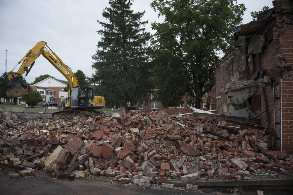 Airmen cleans up waste at condemned building demolition site