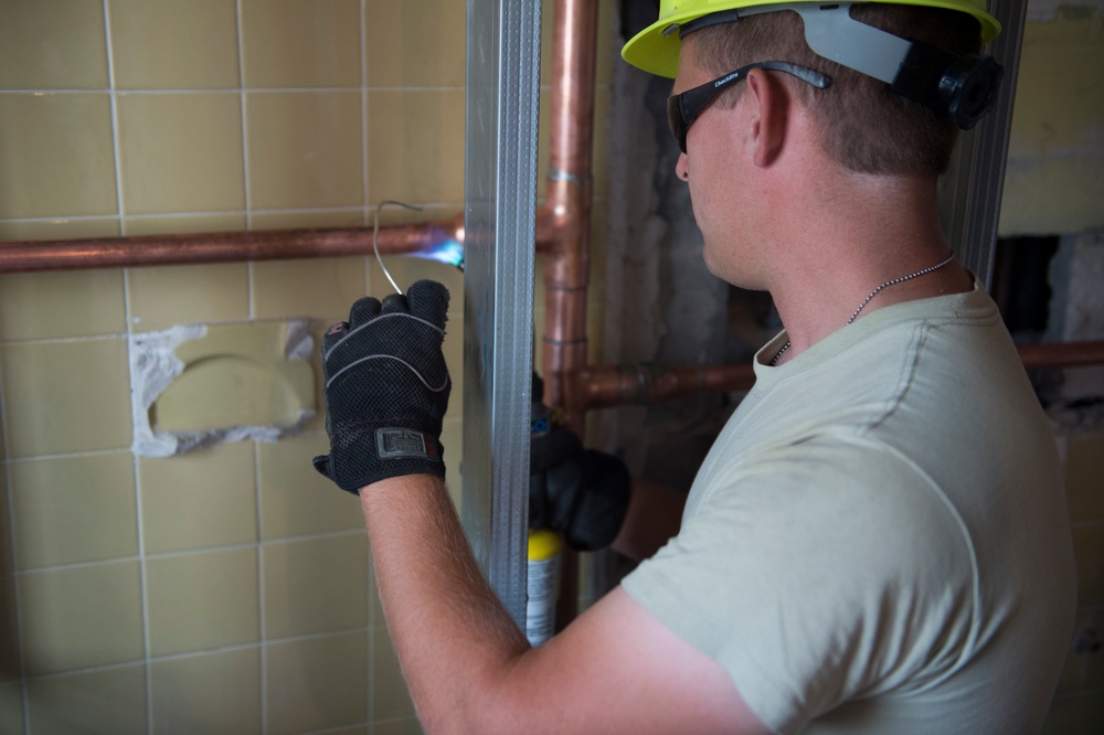 Airman solders copper piping for plumbing during Innovative Readiness Training