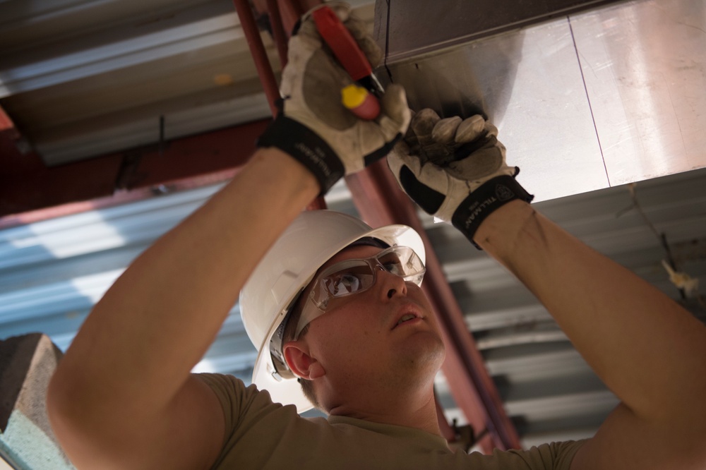 Airman installs ceiling boxes as part of Innovative Readiness Training