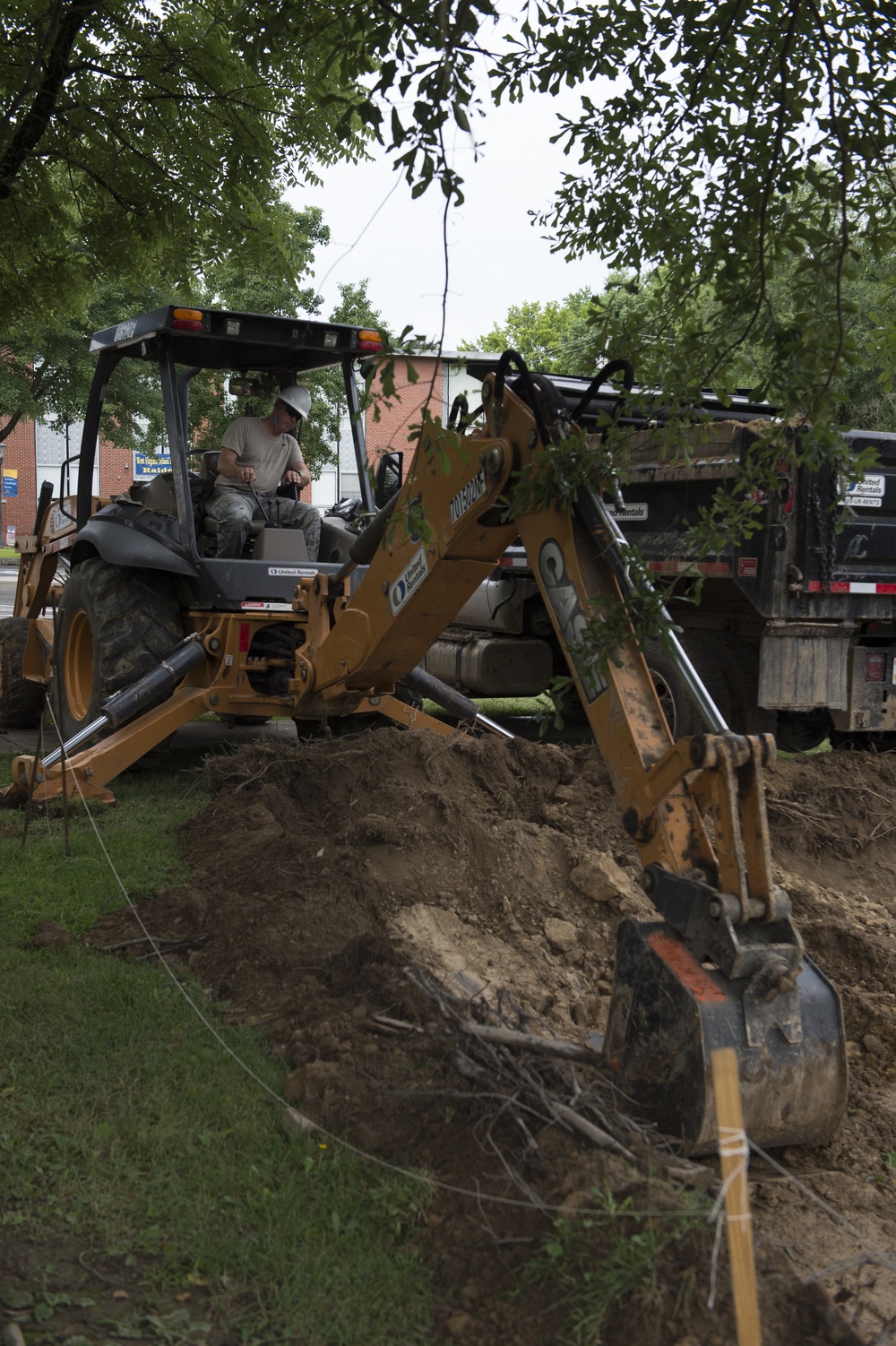 Airman operates excavator to dig for parking lot being built