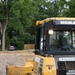 Airmen operates a bulldozer to spread road mix for parking lot