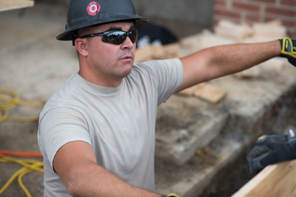 Airman assists with wheelchair ramp being built during Innovative Readiness Training