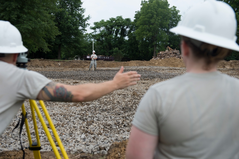 Airmen work on a new parking lot for school during Innovative Readiness Training