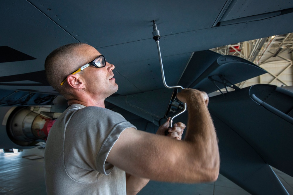 Crew chiefs perform wing maintenance on C-17