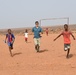 U.S. service members play soccer with local children