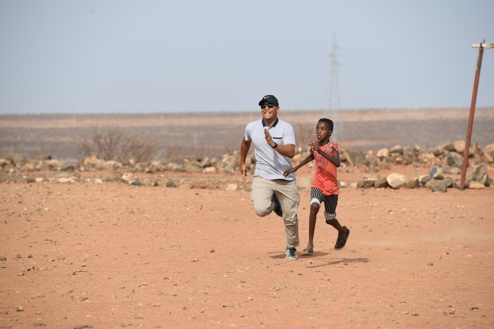 U.S. service members play soccer with local children