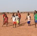 U.S. service members play soccer with local children