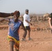 U.S. service members play soccer with local children