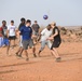 U.S. service members play soccer with local children