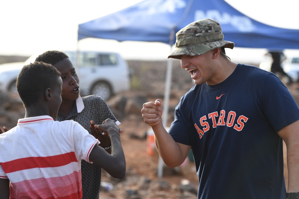 U.S. service members play soccer with local children