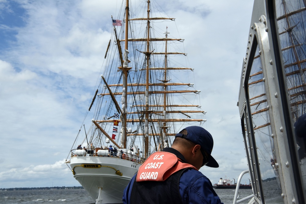 A Coast Guard Cutter Razorbill crewmember prepares to come along side the Coast Guard Cutter Barque Eagle