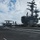 An E-2D Hawkeye assigned to the “Tigertails” of Carrier Airborne Early Warning Squadron (VAW) 125 lands on the aircraft carrier USS Ronald Reagan (CVN 76) during flight operations.