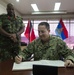 Capt. Brian J. Diebold, commodore of Destroyer Squadron (DESRON) 40, signs a log book at the Trinidad and Tobago Defence Force headquarters