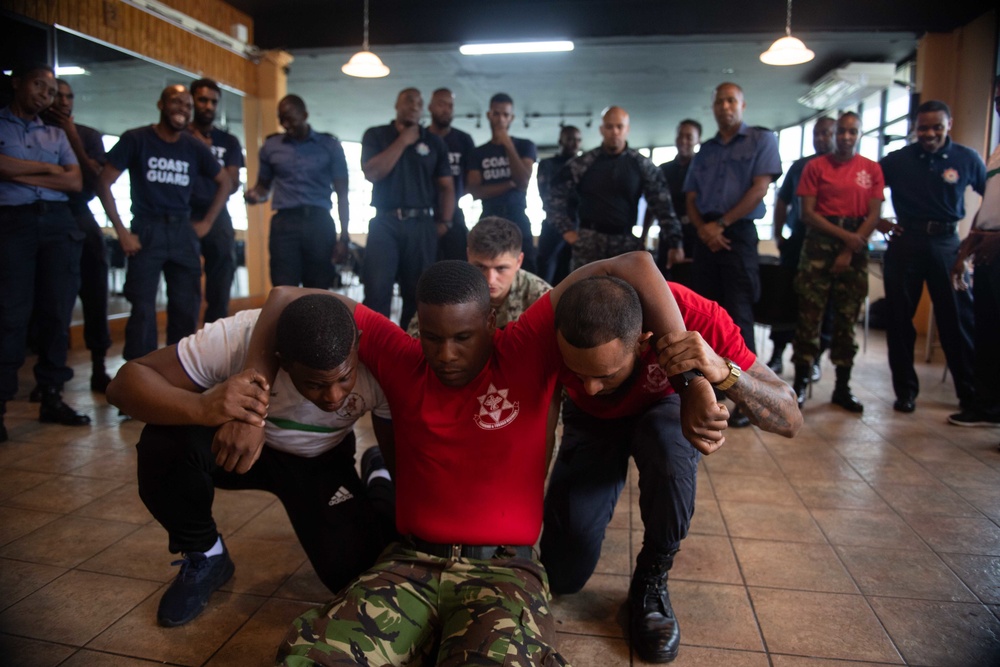 Hospital Corpsman 3rd Class Bishop Sisemore, from Summers, A.R., observes Trinidad and Tobago (TTO) military professionals perform a shoulder-belt carry as part of a subject matter expert exchange