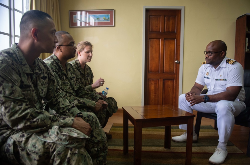 U.S. Navy Sailors meet with a Trinidad and Tobago (TTO) military professional at the TTO Coast Guard base as part of a subject matter exchange