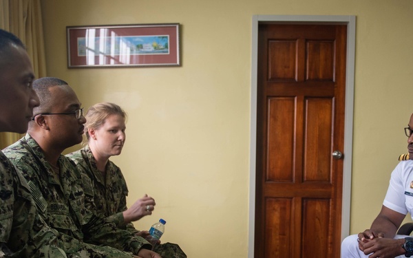 U.S. Navy Sailors meet with a Trinidad and Tobago (TTO) military professional at the TTO Coast Guard base as part of a subject matter exchange