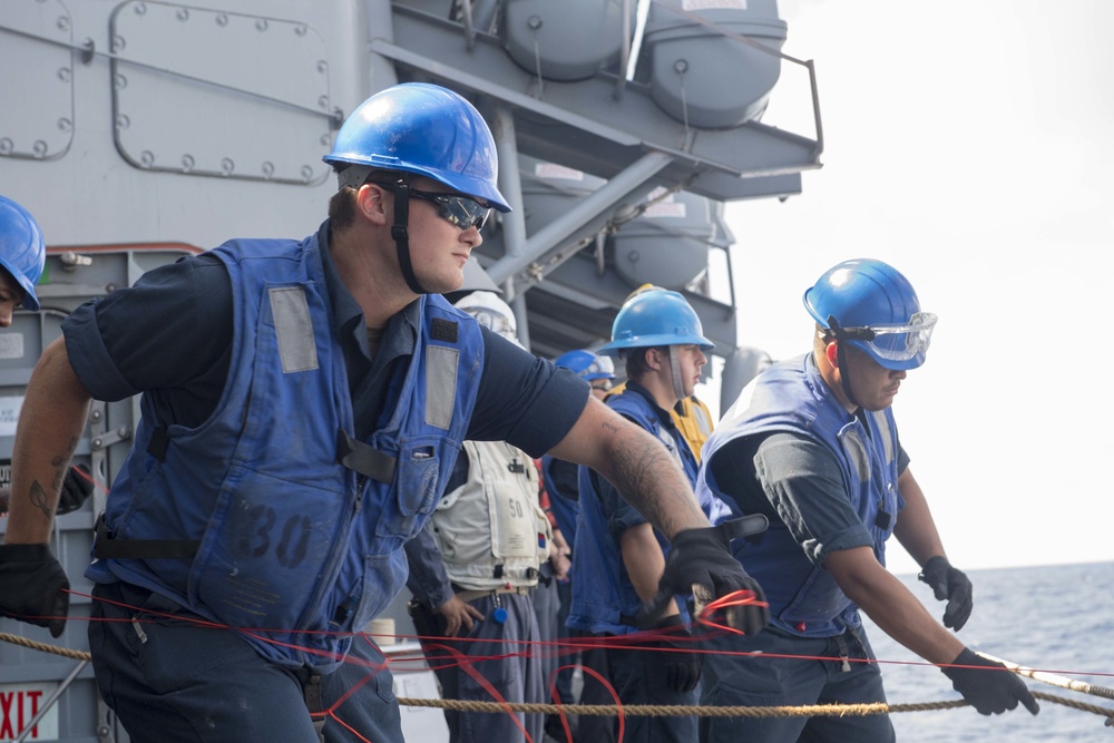 USS Antietam (CG 54) Sailor heaves a line during an underway replenishment with USNS Tippecanoe (T-AO-199)