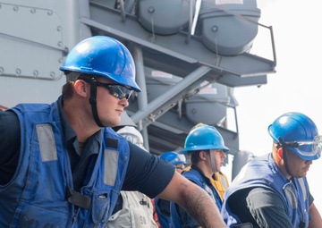 USS Antietam (CG 54) Sailor heaves a line during an underway replenishment with USNS Tippecanoe (T-AO-199)