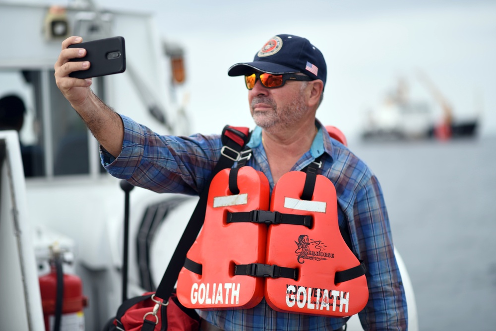 A Panama Canal Authority crewmember takes a selfie in front of the Coast Guard Cutter Fir