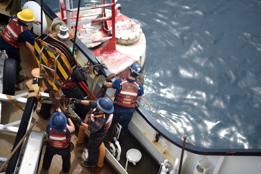 Coast Guard Cutter Fir crewmembers rig a Panamanian whistle buoy before lifting it out of the ocean