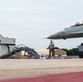 Crew chiefs marshal an F-16 Fighting Falcon