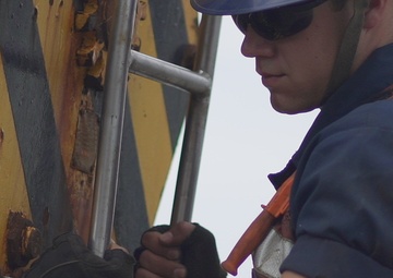 A Coast Guard Cutter Fir guardsman prepares to lift a whistle buoy out of the Port of Panama