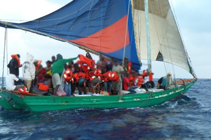 A Sail freighter with 105 Haitian migrants aboard makes way to Haiti while the Coast Guard Cutter Northland escorts them back to safety