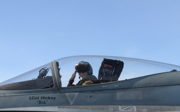 A pilot is seated in the cockpit of a Royal Canadian Air Force (RCAF) fighter jet, appearing to salute. The aircraft is marked with 'RCAF ARC' on the fuselage and identifies the assigned pilot as 'LCol Hickey' with the callsign 'Buk'. The image is taken at close range on what appears to be a tarmac under clear skies.