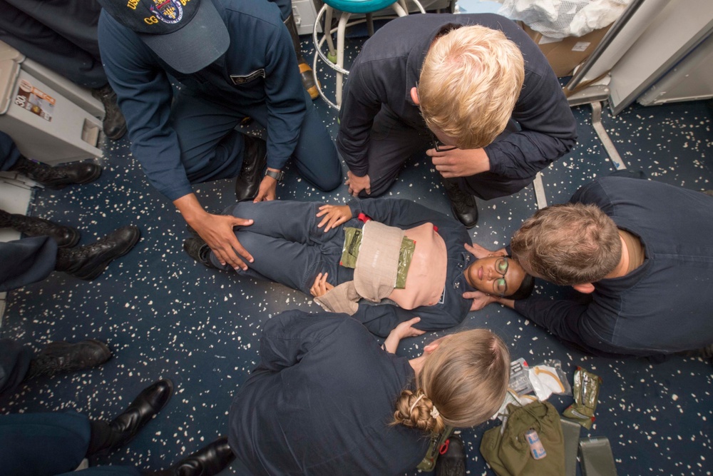 Hospital Corpsman 2nd Class Devina Gutual, from Salinas, CA, receives medical attention as a simulated casualty during a general quarters training exercise on the Ticonderoga-class guided-missile cruiser USS Antietam (CG 54).
