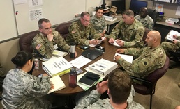 Officers convene for a daily meeting in the JLOC