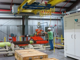 A Letterkenny Munitions Center employee transfers a Multiple Launch Rocket Systems rocket motor from the demating fixture to the RMIS for X-Ray inspection at Letterkenny Munitions Center.