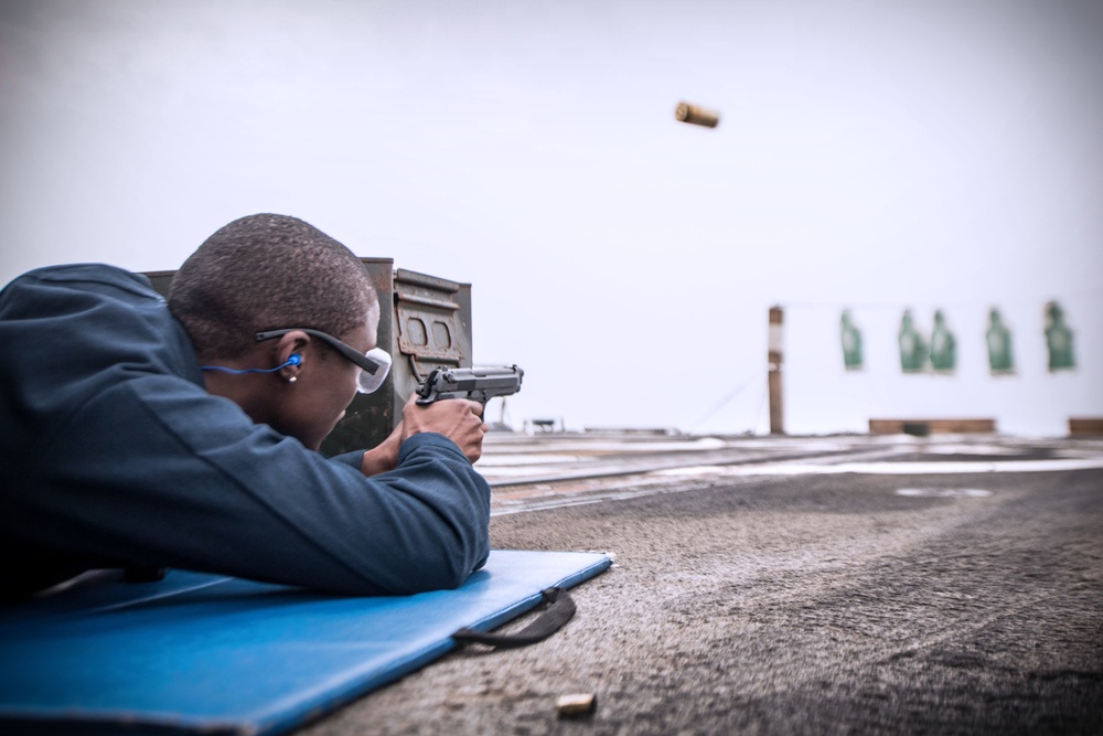 Sailors shoot guns for pistol qualification on USS Jason Dunham