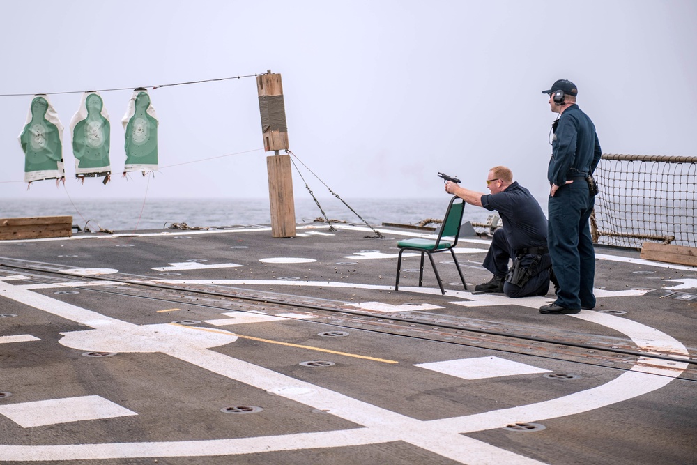 Sailors shoot guns for pistol qualification on USS Jason Dunham