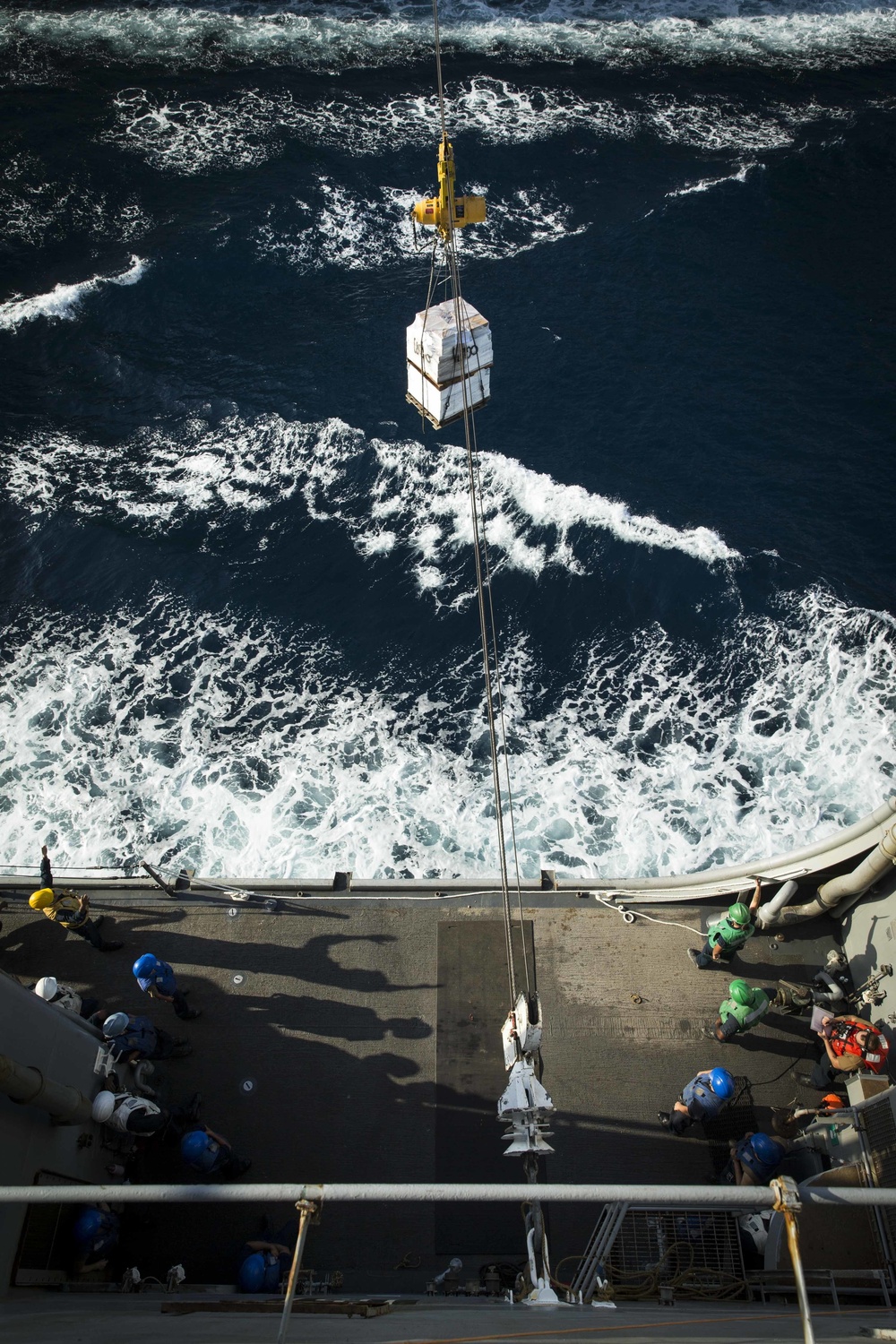 Marines and Sailors receive food supplies and mail during a replenishment-at-sea