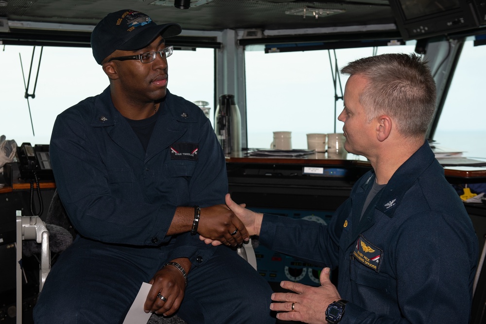 Information Systems Technician 3rd Class Ryan Timberlake, from Houston, receives a Commanding Officer’s coin from Commanding Officer Capt. Randy Peck as the Sailor of the Day aboard the Nimitz-class aircraft carrier USS John C. Stennis (CVN 74).