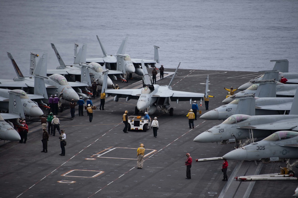 Sailors maneuver an F/A-18E Super Hornet, with Strike Fighter Squadron (VFA) 151, while preparing for flight operations on the flight deck aboard the Nimitz-class aircraft carrier USS John C. Stennis (CVN 74).