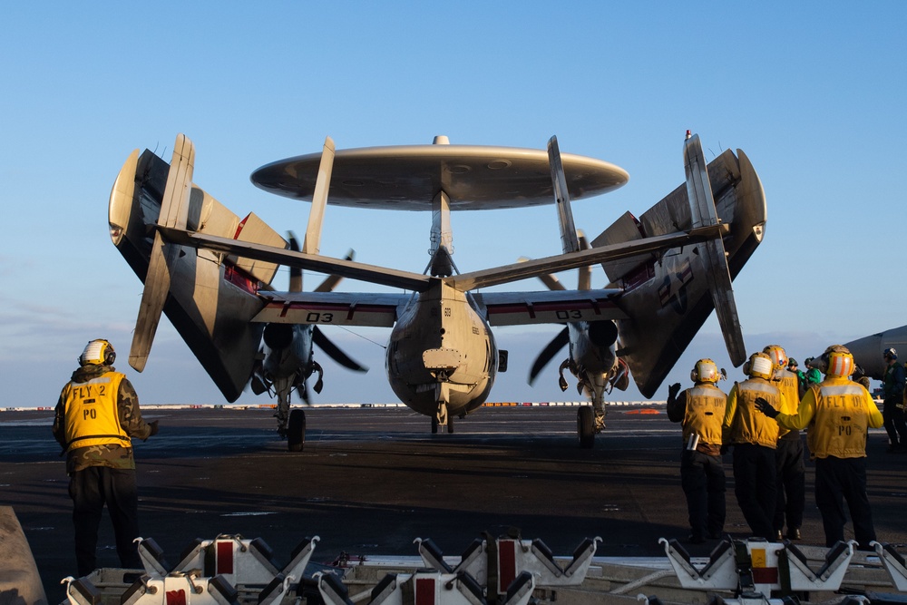 Sailors guide an E-2C Hawkeye, with Carrier Airborne Early Warning Squadron (VAW) 117, into position on the flight deck prior to flight operations aboard the Nimitz-class aircraft carrier USS John C. Stennis (CVN 74).