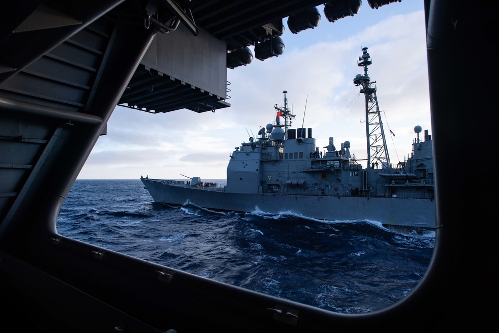 The Ticonderoga-class guided-missile cruiser USS Mobile Bay (CG 53) approaches the Nimitz-class aircraft carrier USS John C. Stennis (CVN 74) for a replenishment-at-sea.