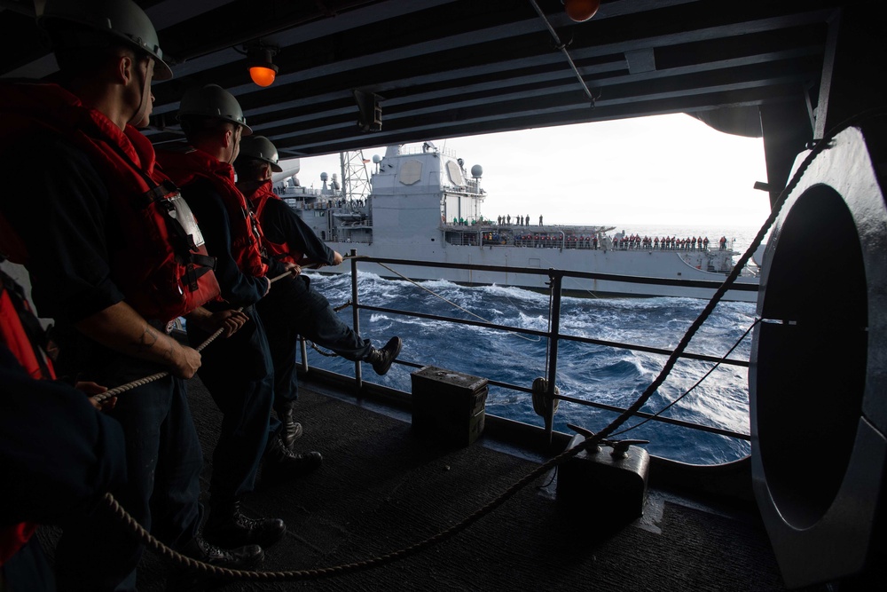 Sailors steady a communications line during a replenishment-at-sea with the Ticonderoga-class guided-missile cruiser USS Mobile Bay (CG 53) aboard the Nimitz-class aircraft carrier USS John C. Stennis (CVN 74).
